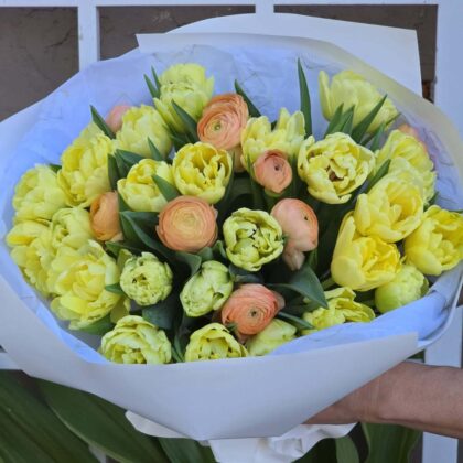 Double Peony Tulips with delicate Peach Ranunculus, elegantly arranged in a bouquet with lush green foliage.