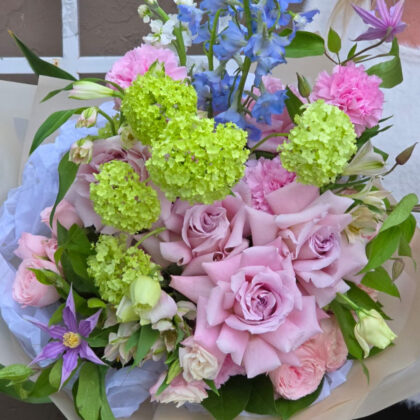 A vibrant spring flower bouquet featuring Double Peony Tulips and peach ranunculus, perfect for any occasion
