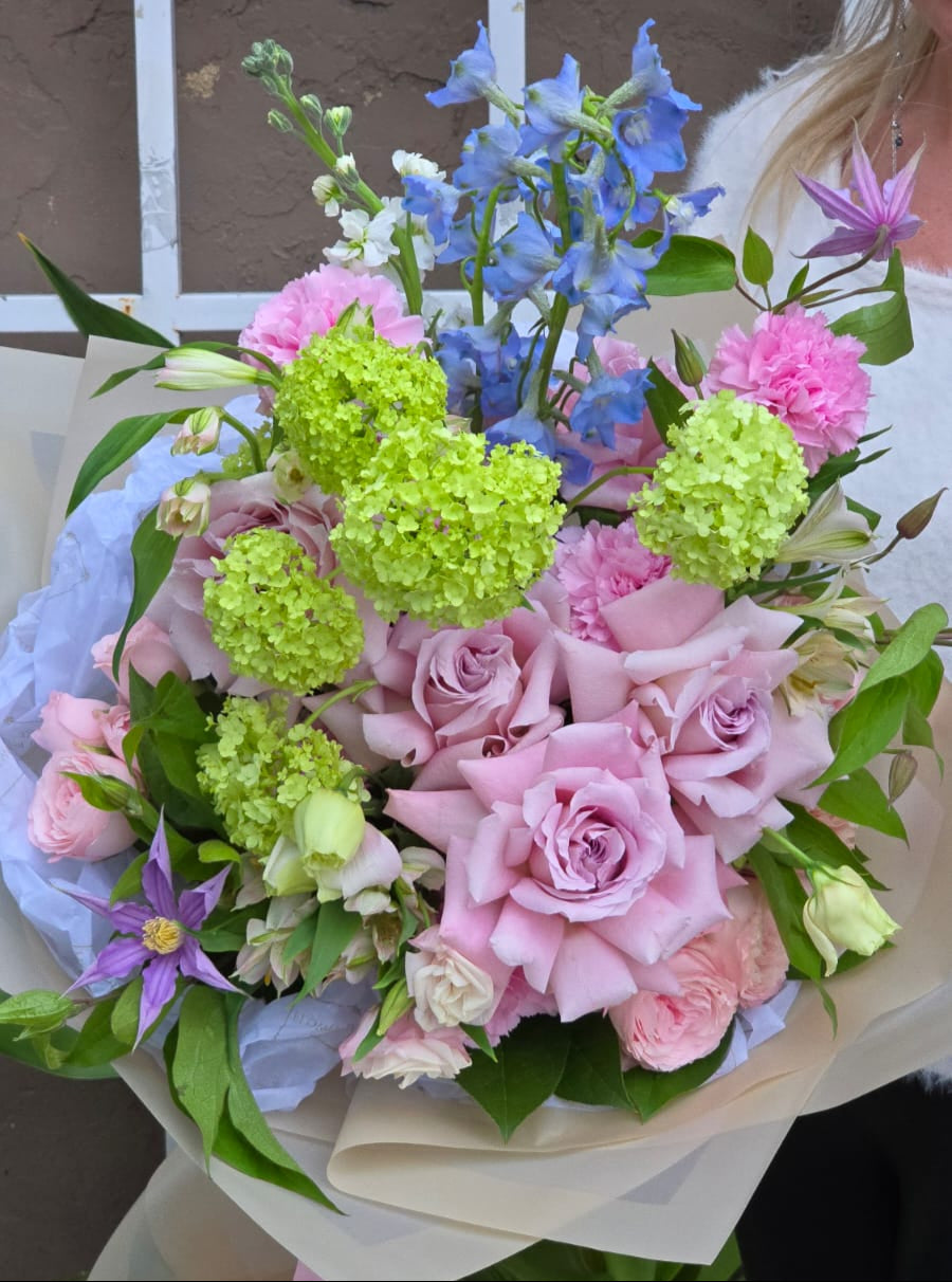 A vibrant spring flower bouquet featuring Double Peony Tulips and peach ranunculus, perfect for any occasion