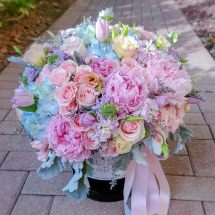 A pastel flower box featuring a dreamy arrangement of roses, peonies, spray roses, and stock in soft, delicate hues, creating an enchanting and elegant display that exudes grace and charm, perfect for any special occasion or heartfelt gesture.