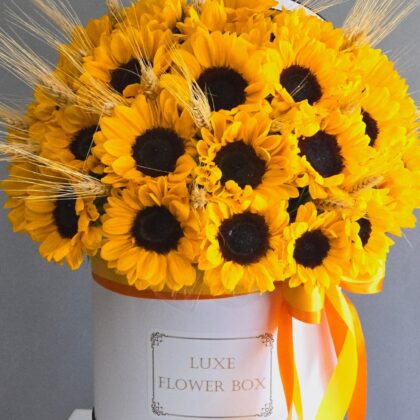 A rustic bouquet featuring vibrant yellow sunflowers paired with golden wheat stalks, creating a warm and earthy arrangement perfect for autumn or a country-inspired setting.